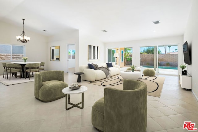 living room featuring vaulted ceiling, light tile patterned floors, and a chandelier