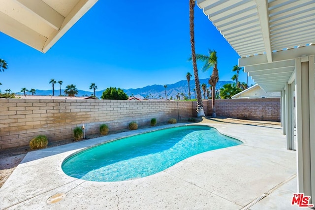 view of swimming pool featuring a mountain view and a patio