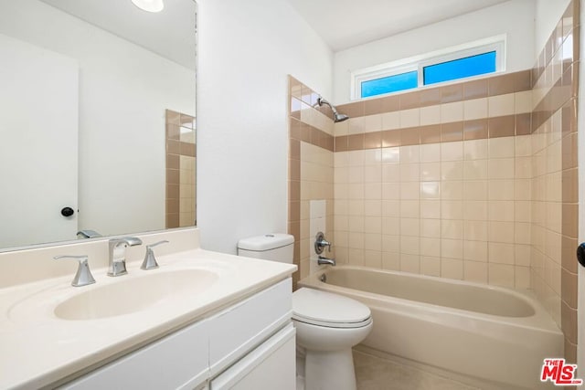 full bathroom featuring vanity, tiled shower / bath combo, and toilet