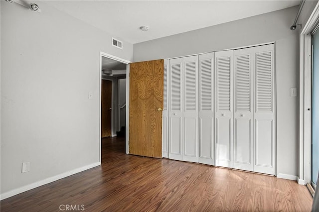 unfurnished bedroom with wood-type flooring and a closet