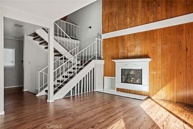 unfurnished living room featuring hardwood / wood-style flooring and wood walls