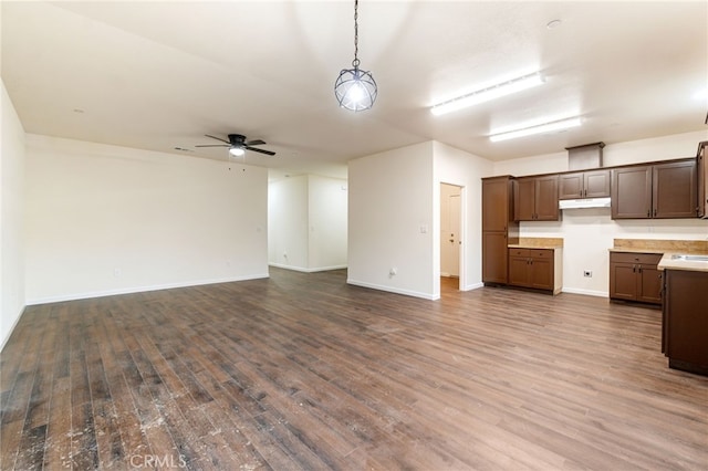 unfurnished living room with ceiling fan and dark hardwood / wood-style flooring