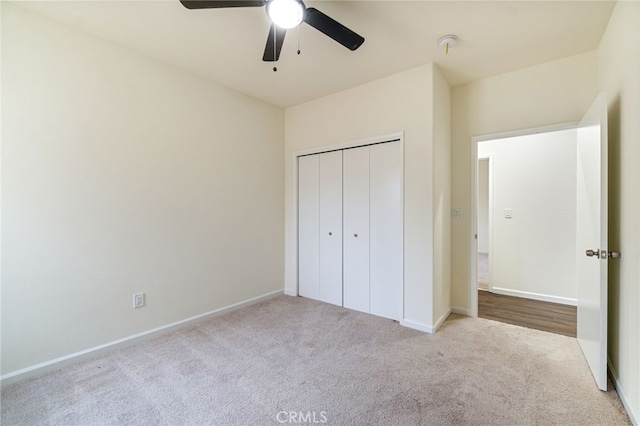 unfurnished bedroom with ceiling fan, light colored carpet, and a closet