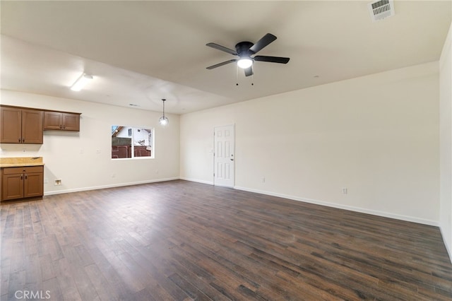 unfurnished living room featuring ceiling fan and dark wood-type flooring