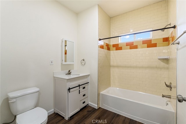 full bathroom with hardwood / wood-style floors, vanity, toilet, and tiled shower / bath