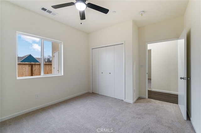 unfurnished bedroom with ceiling fan, a closet, and light colored carpet