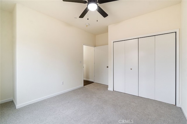 unfurnished bedroom with ceiling fan, a closet, and light colored carpet