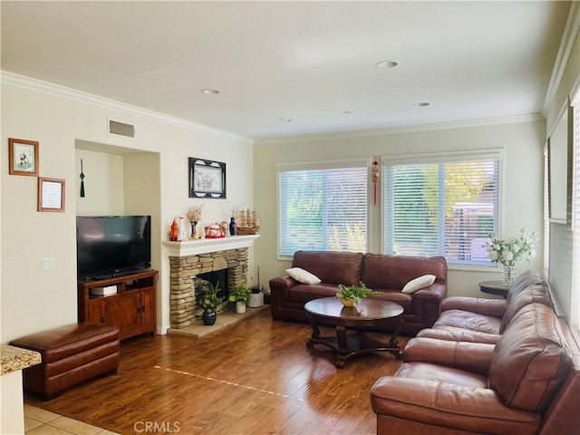 living room featuring hardwood / wood-style floors, ornamental molding, and a fireplace