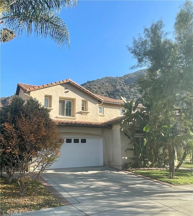 mediterranean / spanish home with a garage and a mountain view