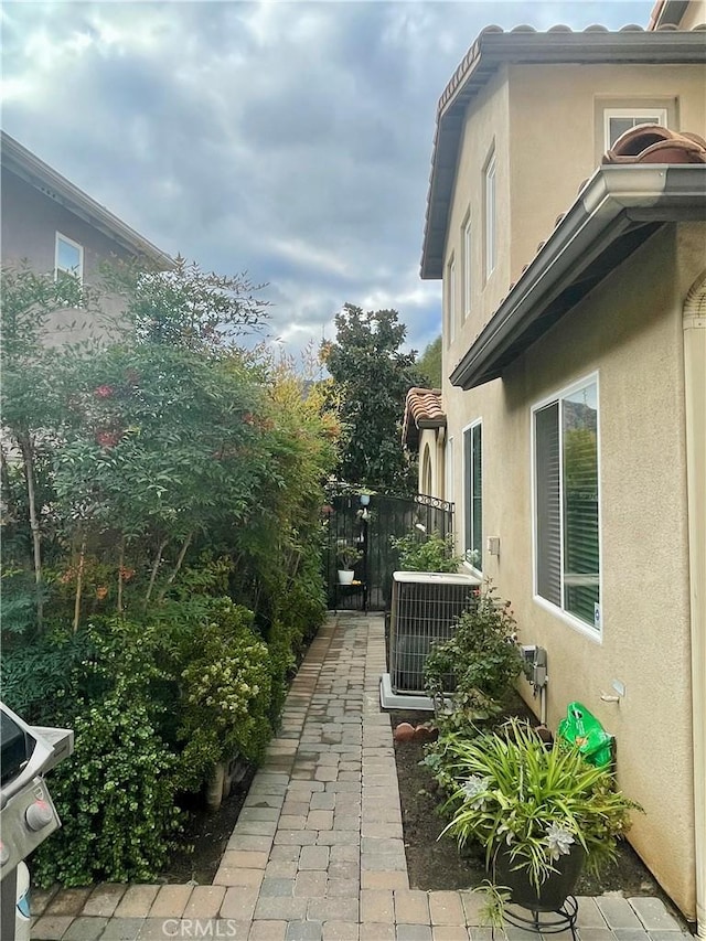 view of property exterior featuring central AC unit and a patio