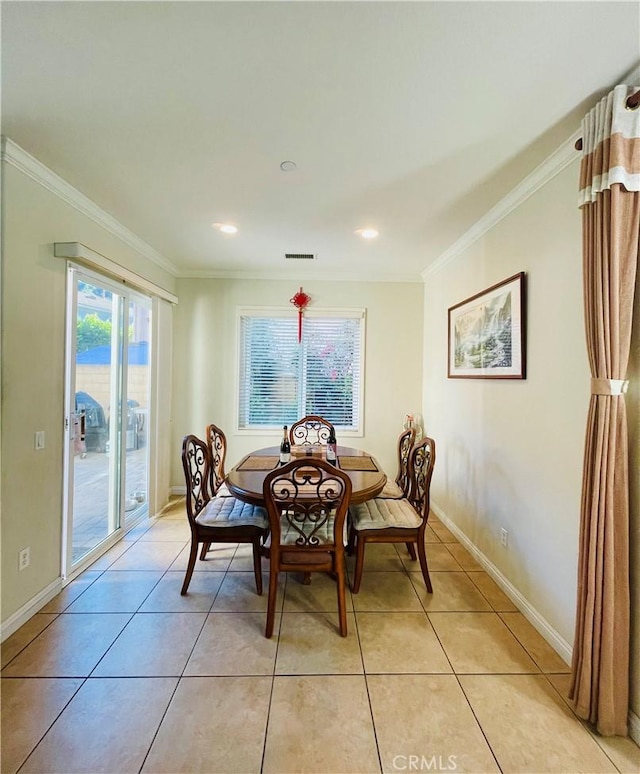 dining room featuring light tile patterned floors and crown molding