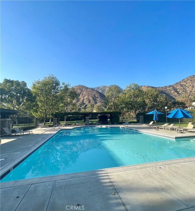 view of pool featuring a mountain view and a patio