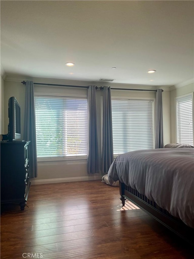 bedroom with dark wood-type flooring and crown molding