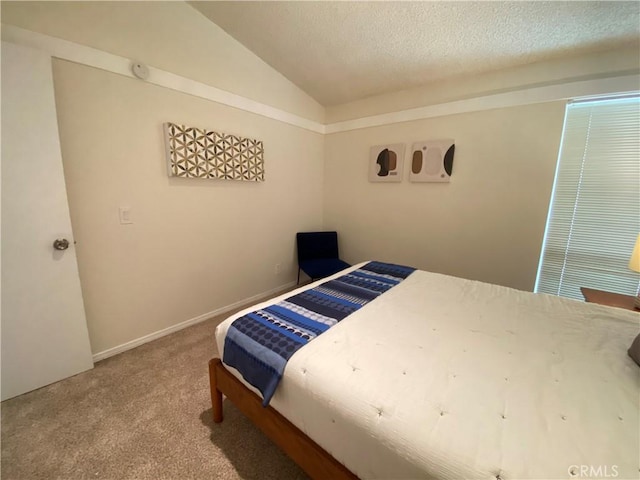 bedroom featuring a textured ceiling, carpet floors, and vaulted ceiling