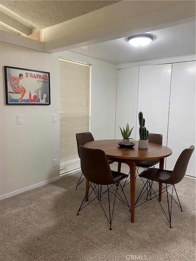 dining space with carpet and a textured ceiling