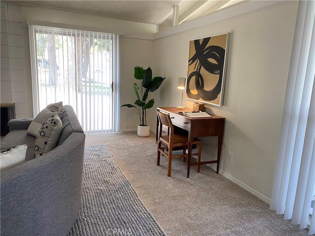 home office with lofted ceiling, carpet, and a textured ceiling