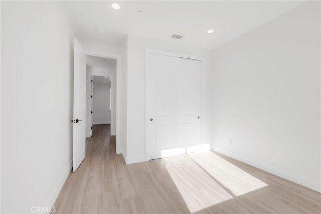 unfurnished bedroom featuring light hardwood / wood-style floors and a closet