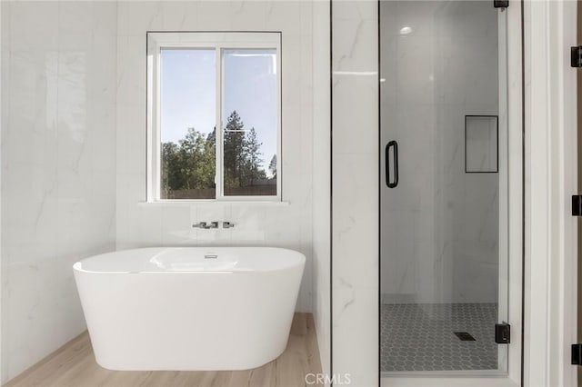 bathroom with plus walk in shower and hardwood / wood-style flooring