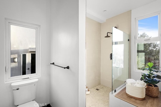 bathroom with toilet and a tile shower