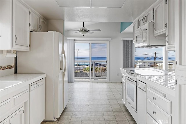 kitchen featuring ceiling fan, white appliances, tile countertops, and white cabinetry