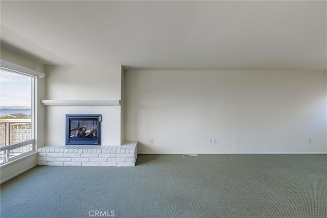 unfurnished living room featuring carpet, a healthy amount of sunlight, and a fireplace