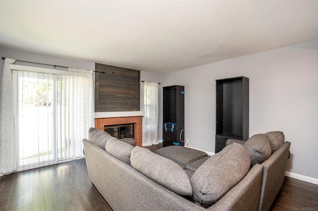 living room with a fireplace and dark wood-type flooring