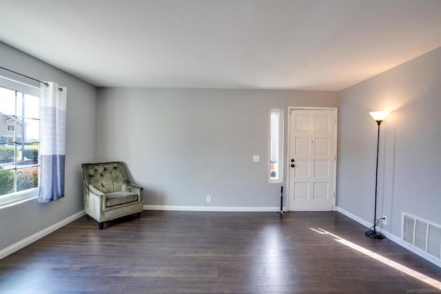 unfurnished room featuring dark wood-type flooring and a healthy amount of sunlight