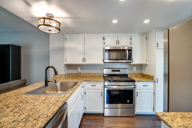 kitchen featuring dark wood-type flooring, white cabinets, sink, appliances with stainless steel finishes, and light stone counters