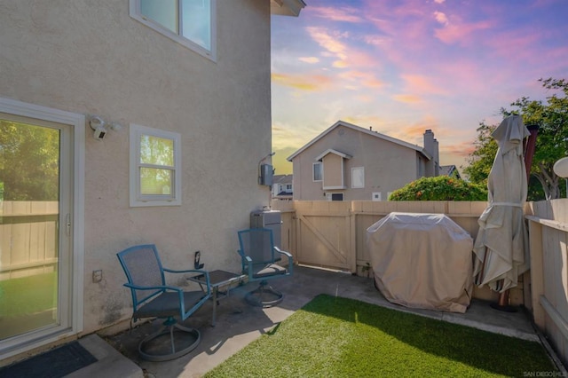 yard at dusk with a patio area