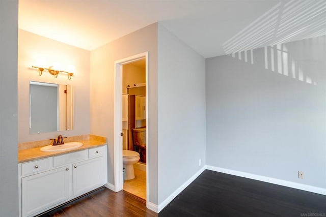 bathroom featuring vanity, hardwood / wood-style flooring, and toilet