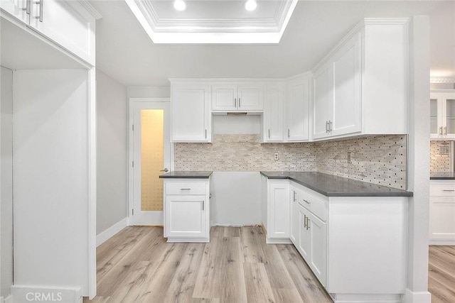 kitchen featuring a tray ceiling, light hardwood / wood-style flooring, and white cabinets