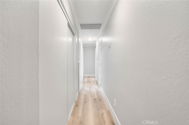 hallway featuring light hardwood / wood-style floors and crown molding