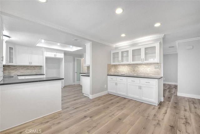 kitchen with light wood-type flooring, white cabinetry, and ornamental molding