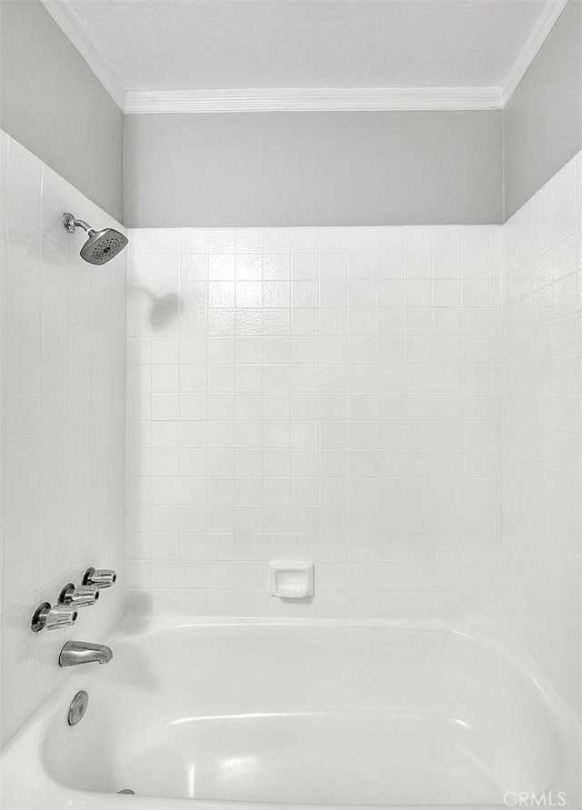 bathroom featuring crown molding and tiled shower / bath