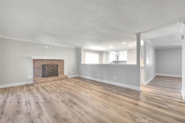 unfurnished living room with a fireplace, a textured ceiling, light hardwood / wood-style floors, and crown molding