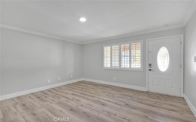 foyer entrance with ornamental molding and light hardwood / wood-style flooring