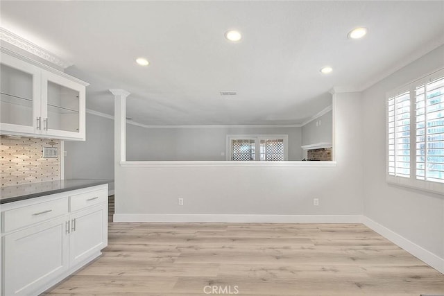 unfurnished dining area featuring crown molding and light wood-type flooring