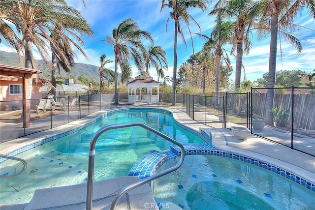 view of swimming pool with an in ground hot tub and a mountain view