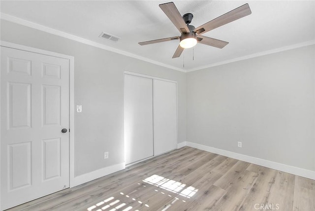 unfurnished bedroom with ceiling fan, ornamental molding, and light hardwood / wood-style flooring