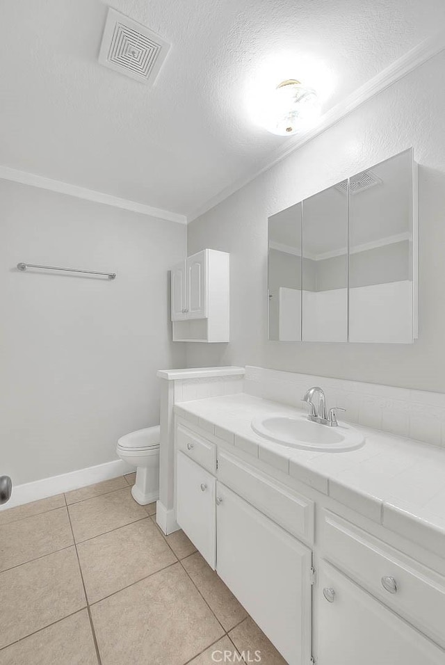 bathroom with tile patterned flooring, vanity, toilet, and a textured ceiling