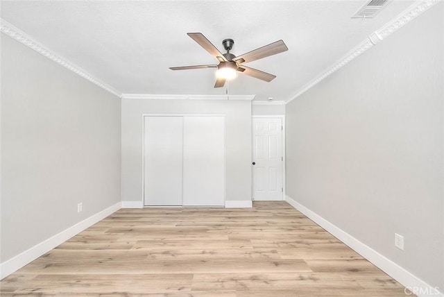 unfurnished bedroom with ceiling fan, ornamental molding, light hardwood / wood-style flooring, and a closet