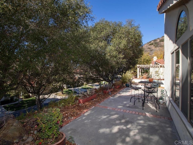 view of patio / terrace with a mountain view and a pergola