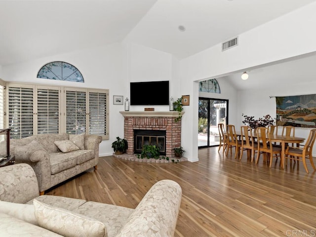 living room with hardwood / wood-style flooring, a fireplace, and lofted ceiling