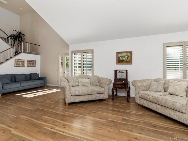 living room with wood-type flooring, high vaulted ceiling, and a wealth of natural light