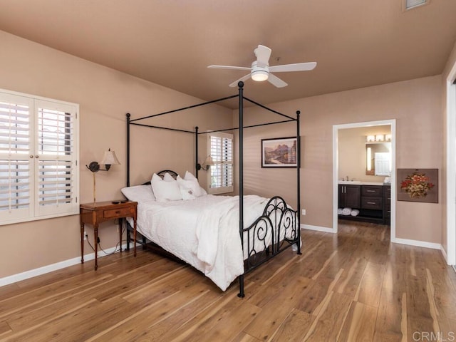 bedroom with ceiling fan, connected bathroom, and hardwood / wood-style flooring