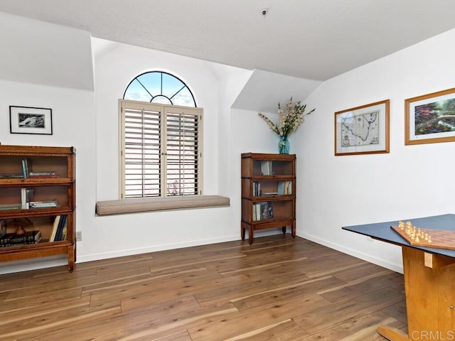 living area with wood-type flooring and vaulted ceiling