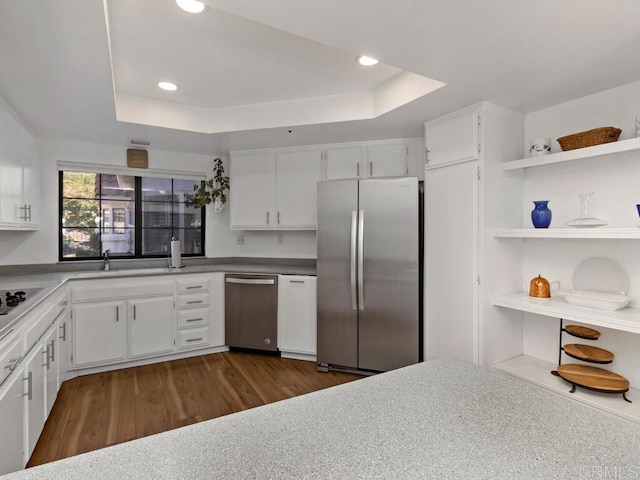 kitchen with a tray ceiling, sink, white cabinetry, and stainless steel fridge