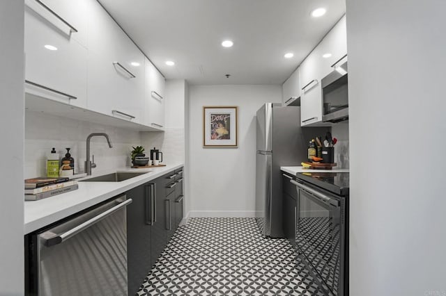 kitchen featuring white cabinets, decorative backsplash, stainless steel appliances, and sink