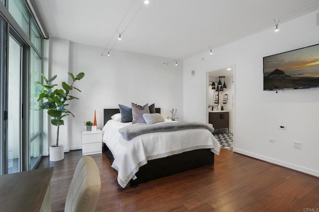 bedroom featuring ensuite bathroom and dark wood-type flooring