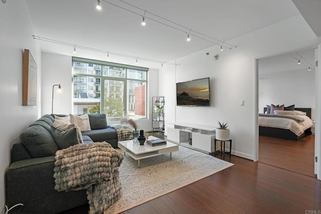 living room featuring rail lighting and dark wood-type flooring